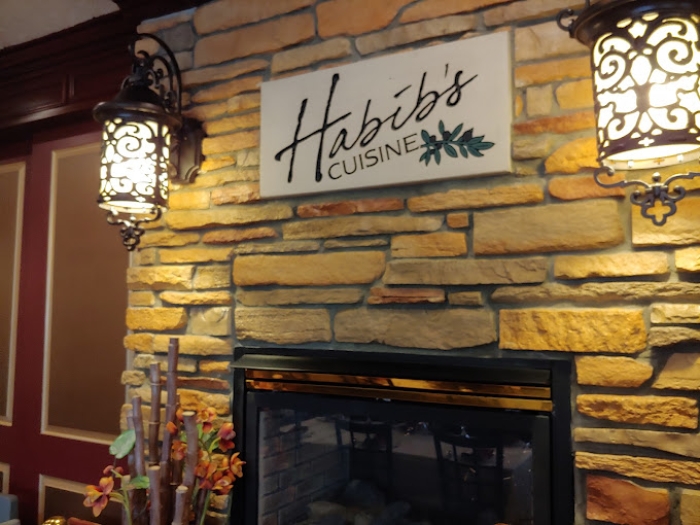 Habib's Cuisine logo above a fireplace