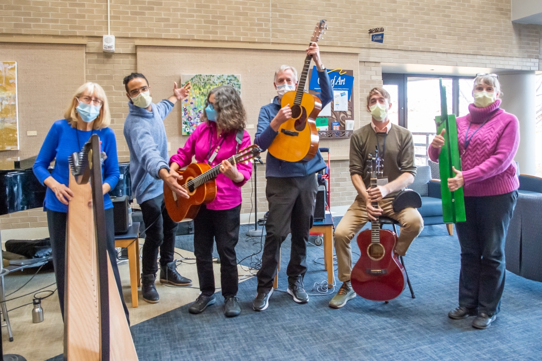 Bedside musicians stand together for photo with instruments