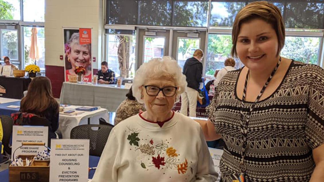 Smiling young and elderly woman pose and look at the camera.